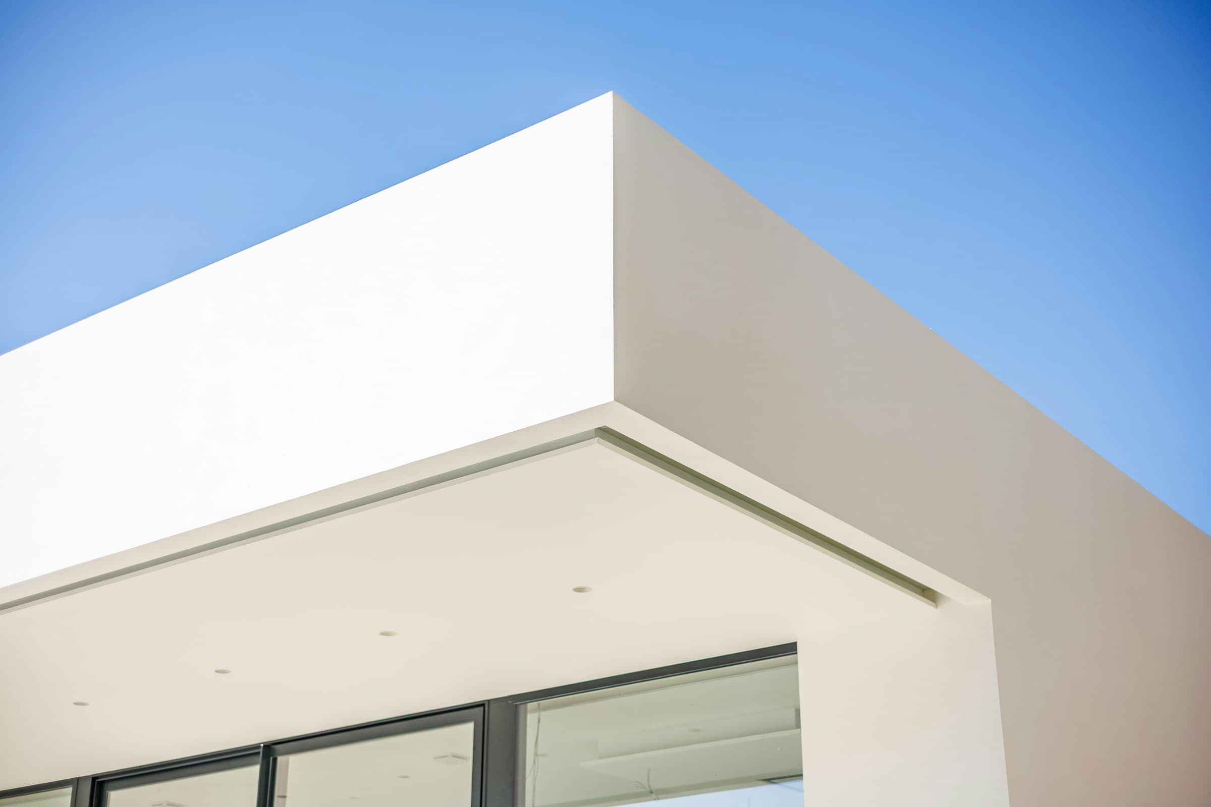 Klare weiße Architektur vor blauem Himmel